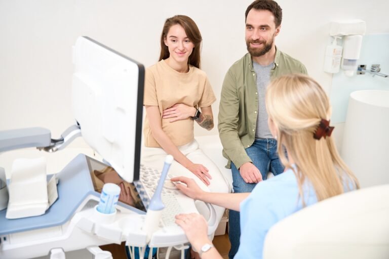 Gynecologist looking at couple watching result of ultrasound scan of woman belly